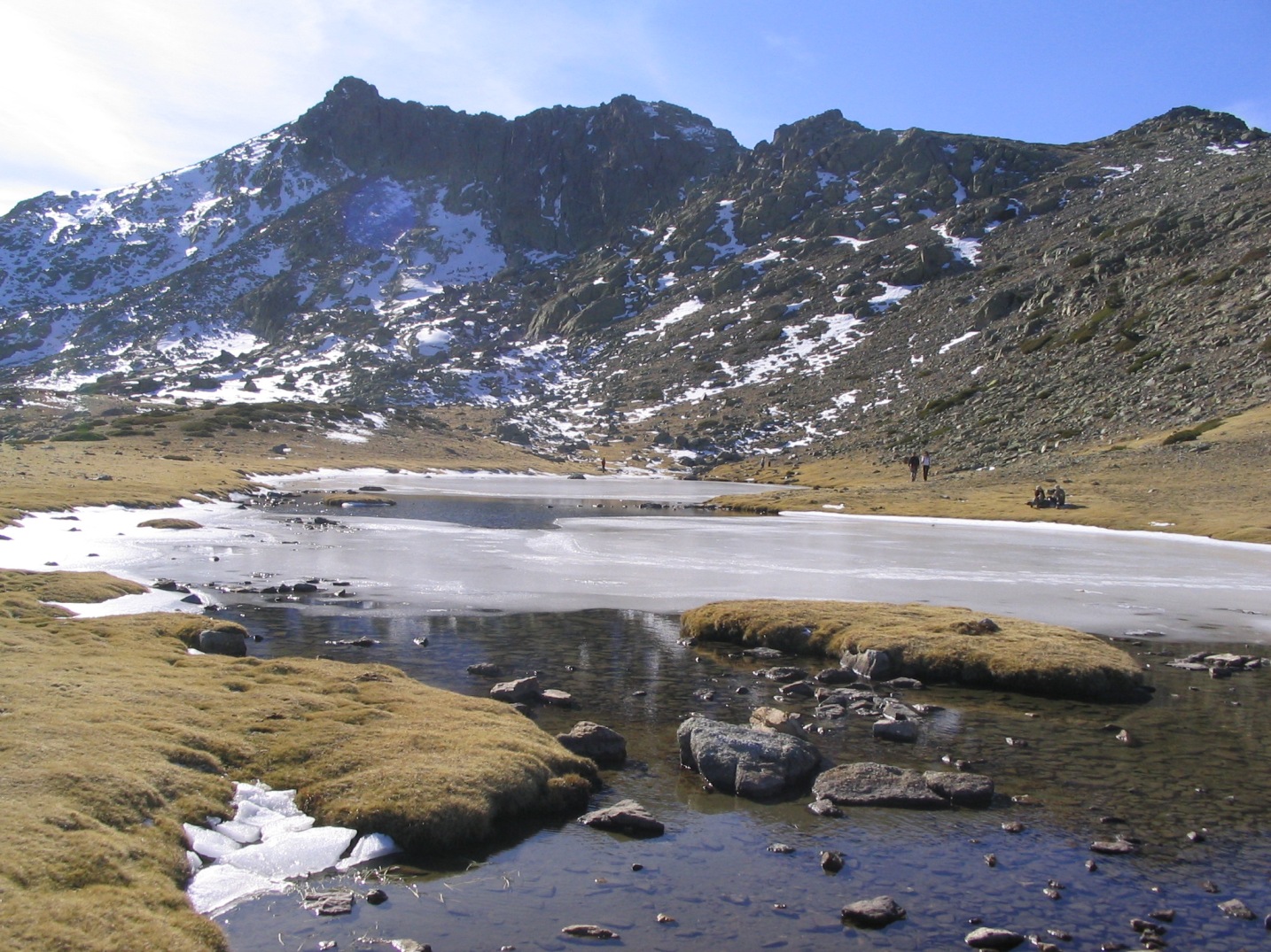Laguna de los Pájaros parcialmente helada con el risco de los Claveles al fondo en Peñalara